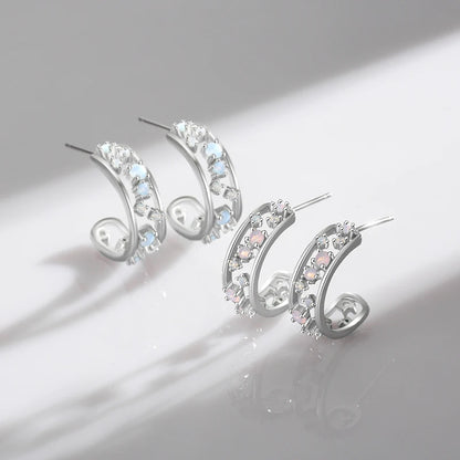 Silver hoop earrings with scattered opalescent and clear stones set in a textured band

