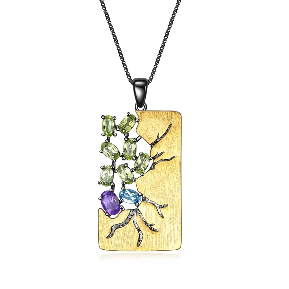 Gold pendant necklace featuring a gemstone tree design with green, blue, and purple stones

