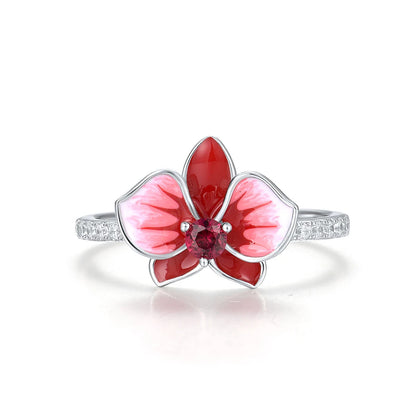 Silver floral ring featuring a red and white enamel orchid with a central ruby-colored stone.

