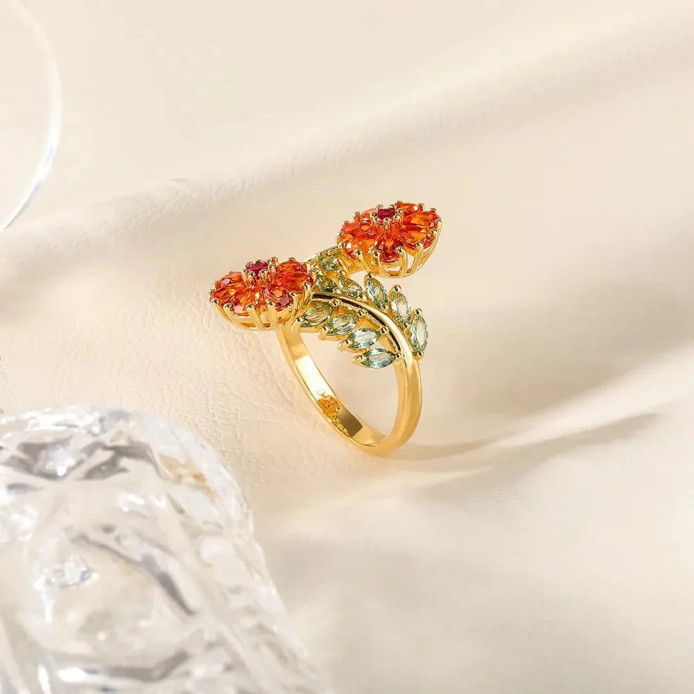 Gold ring with vibrant orange floral gemstones and soft green leaf-shaped stones, Fiore di Cristallo from the Rossa Collection.

