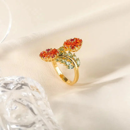 Gold ring with vibrant orange floral gemstones and soft green leaf-shaped stones, Fiore di Cristallo from the Rossa Collection.

