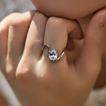 Open silver ring with a triangular wrap design, featuring a prominent oval white stone at its center, from the Bianco Nero collection.

