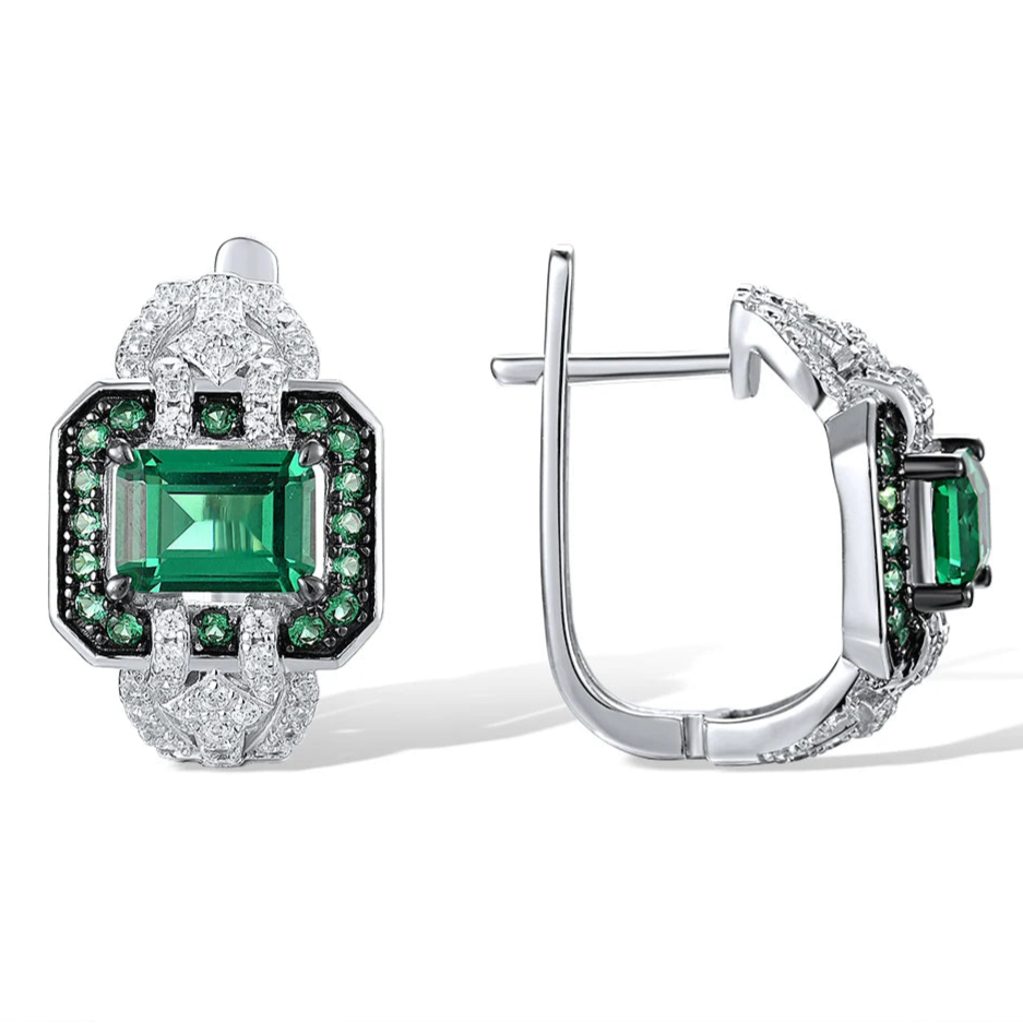 Octagonal silver earrings with emerald-cut green center stones, haloed by smaller green and clear stones

