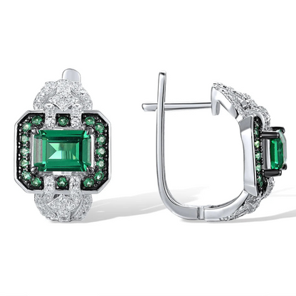 Octagonal silver earrings with emerald-cut green center stones, haloed by smaller green and clear stones


