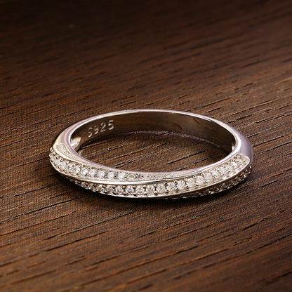 Slim silver ring featuring two parallel rows of small white stones, forming a subtle twist in the center, from the Bianco Nero collection.

