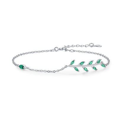 Gold chain bracelet with a delicate green leaf branch design.

