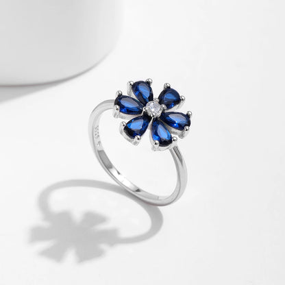 Sterling silver ring with a royal blue gemstone flower and clear stone center

