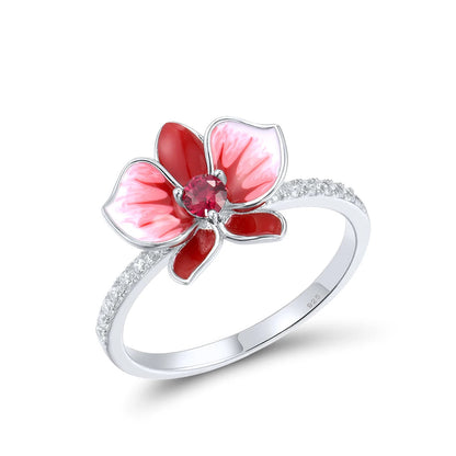 Silver floral ring featuring a red and white enamel orchid with a central ruby-colored stone.

