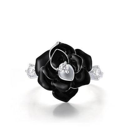 Silver ring with a black enamel rose centerpiece and two clear gemstones on the band.


