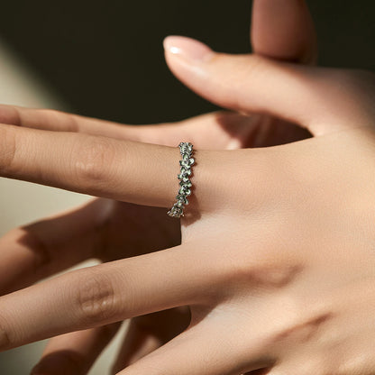 Sterling silver floral band ring with light green enamel petals and tiny diamond accents.

