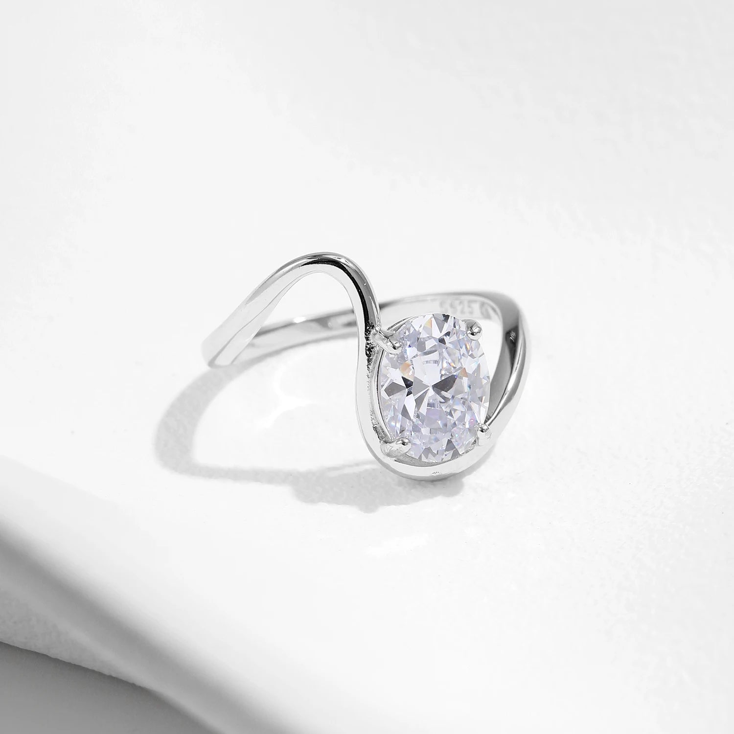 Open silver ring with a triangular wrap design, featuring a prominent oval white stone at its center, from the Bianco Nero collection.

