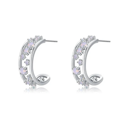 Silver hoop earrings with scattered opalescent and clear stones set in a textured band

