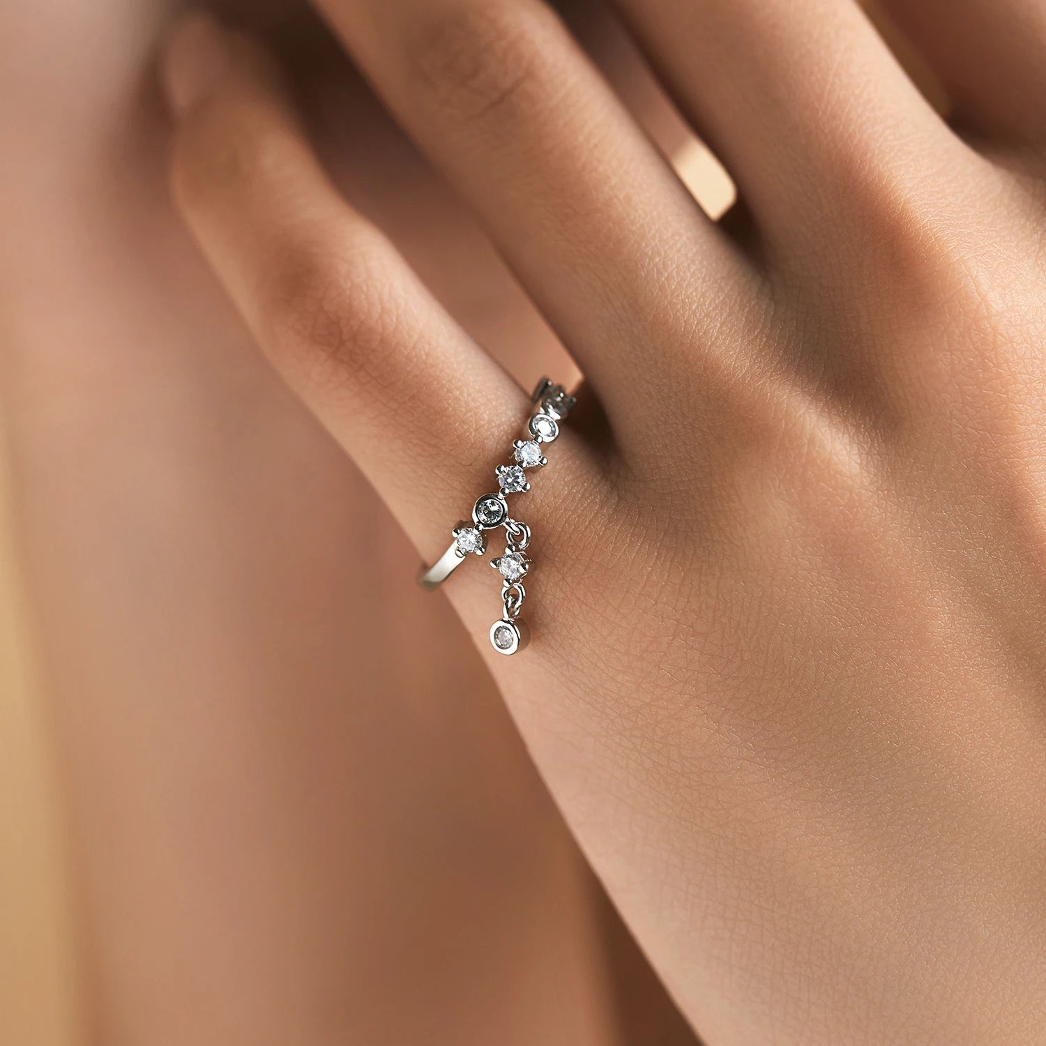 Silver ring with a line of round-cut stones and three delicate cubic zirconia drops