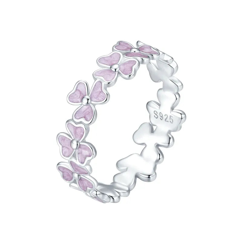 Delicate silver ring featuring small pink enamel flowers in a continuous garland design

