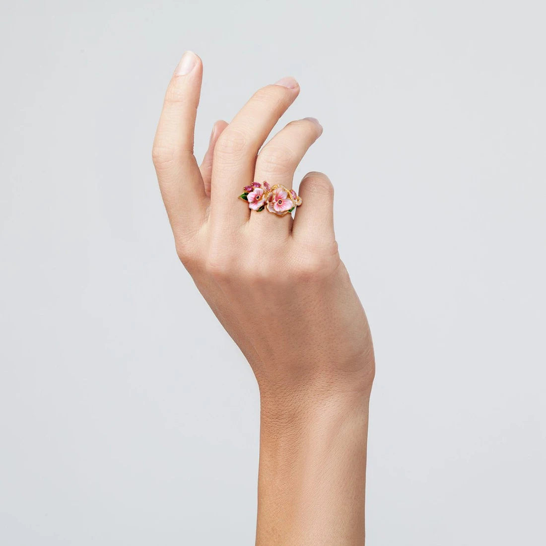 Prato ring with hand-painted pink flowers, green enamel leaves, and pink marquise-cut stones on a gold band.


