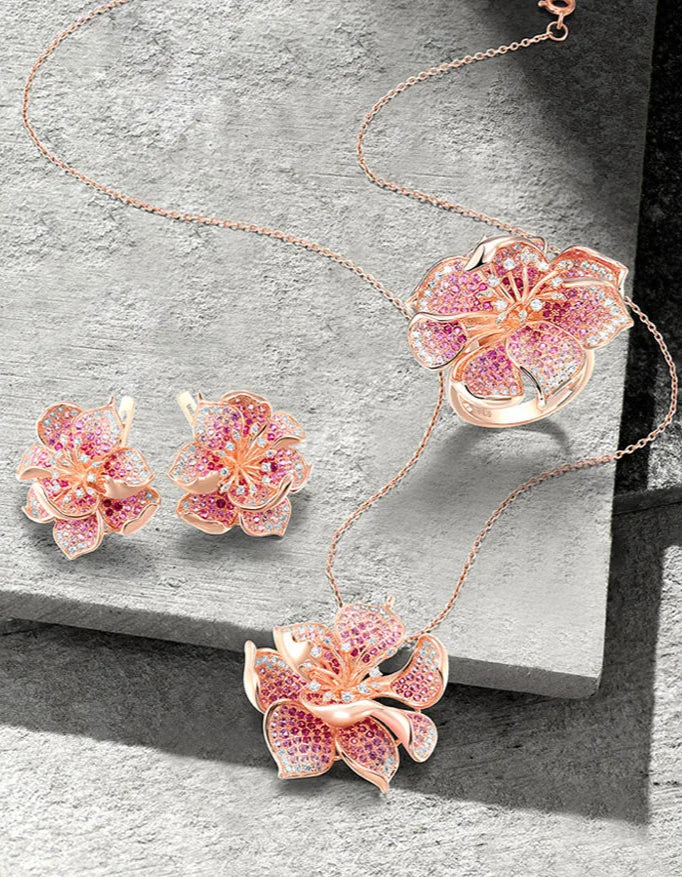 Fragola jewelry set featuring pink and violet pavé stones in rose gold flower designs including ring, earrings, and pendant.

