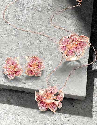 Fragola jewelry set featuring pink and violet pavé stones in rose gold flower designs including ring, earrings, and pendant.

