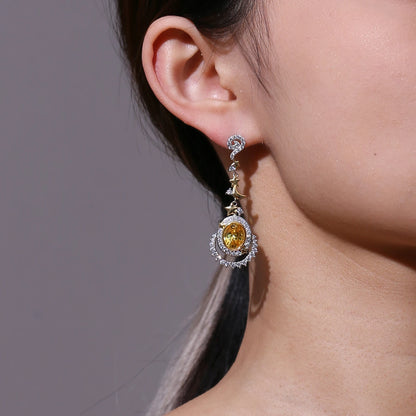 Dangling earrings with yellow gemstones, crescent moons, and star accents in gold and silver

