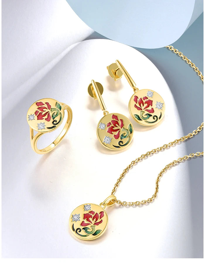 Gold jewelry set featuring red and green floral enamel design on round medallion earrings, pendant, and ring.

