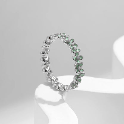 Sterling silver floral band ring with light green enamel petals and tiny diamond accents.

