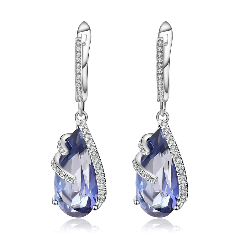 Silver earrings with faceted blue teardrop stones and delicate pavé accents

