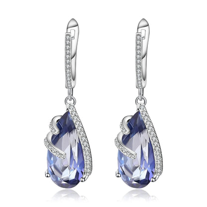 Silver earrings with faceted blue teardrop stones and delicate pavé accents

