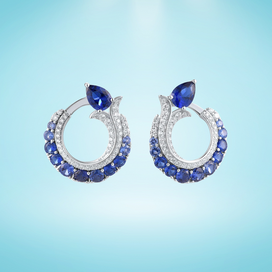 Sterling silver hoop earrings with pavé and deep blue pear-shaped sapphires.

