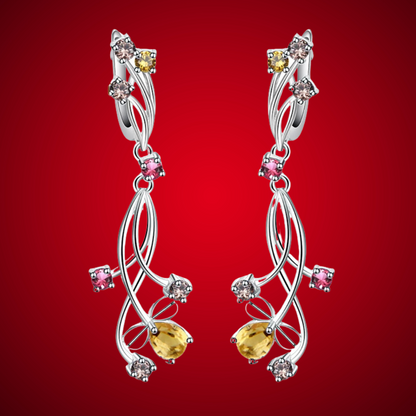 Pair of silver drop earrings with yellow teardrop stones and mixed round gemstones in pink, champagne, and yellow tones.

