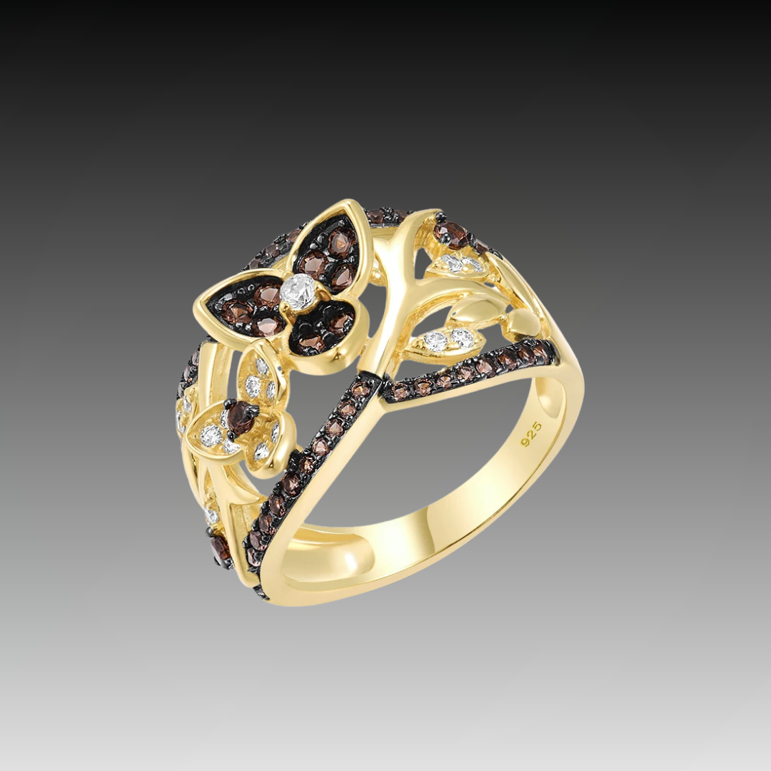 Gold-toned ring with dark butterfly and branch design, accented by brown and white stones

