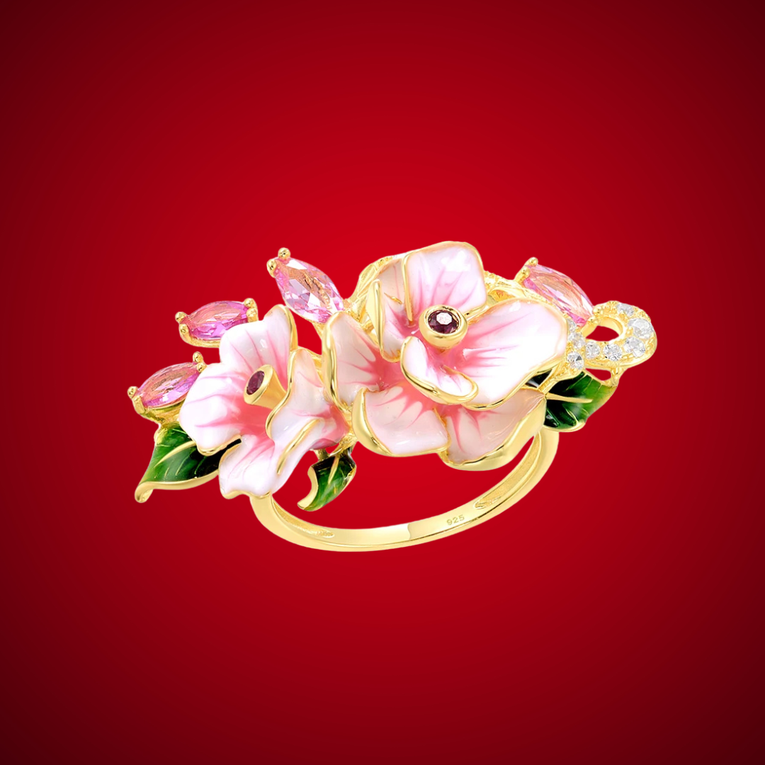 Prato ring with hand-painted pink flowers, green enamel leaves, and pink marquise-cut stones on a gold band.

