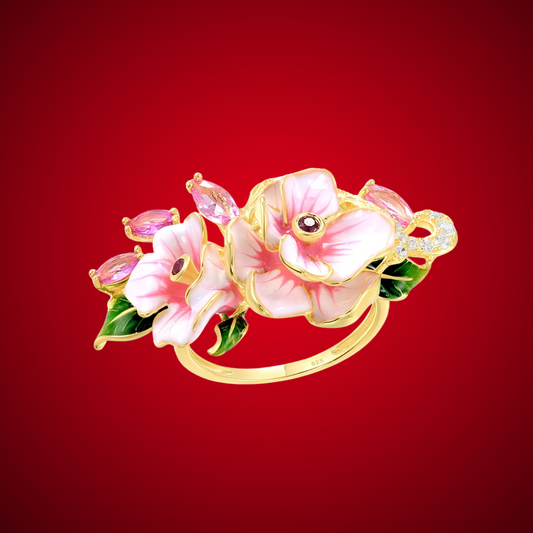Prato ring with hand-painted pink flowers, green enamel leaves, and pink marquise-cut stones on a gold band.

