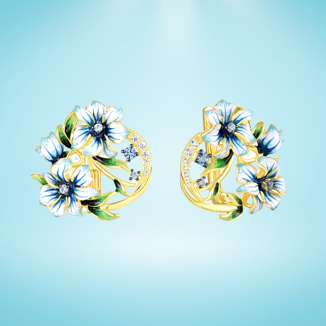 Gold-tone earrings with white and blue enamel flowers and crystal accents

