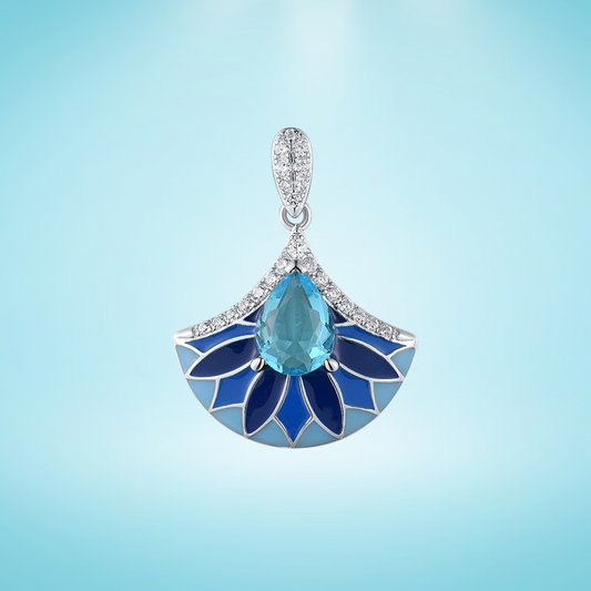 Sterling silver pendant with a teardrop-shaped aqua blue gemstone above a fan-shaped design of layered navy and cobalt enamel petals, framed by pavé stones, on a light blue background