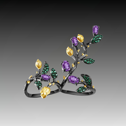 Double-finger black ring shaped like a flowering branch with purple, green, and gold detailing


