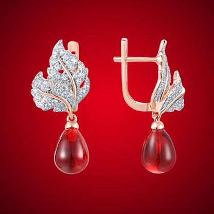 Lapino earrings with crystal-paved silver-tone leaves and rich red teardrop gemstone drops.

