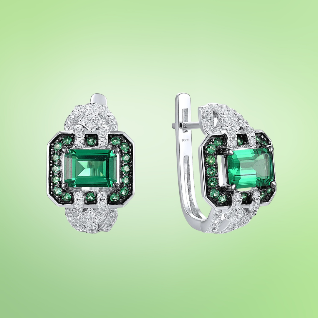 Octagonal silver earrings with emerald-cut green center stones, haloed by smaller green and clear stones

