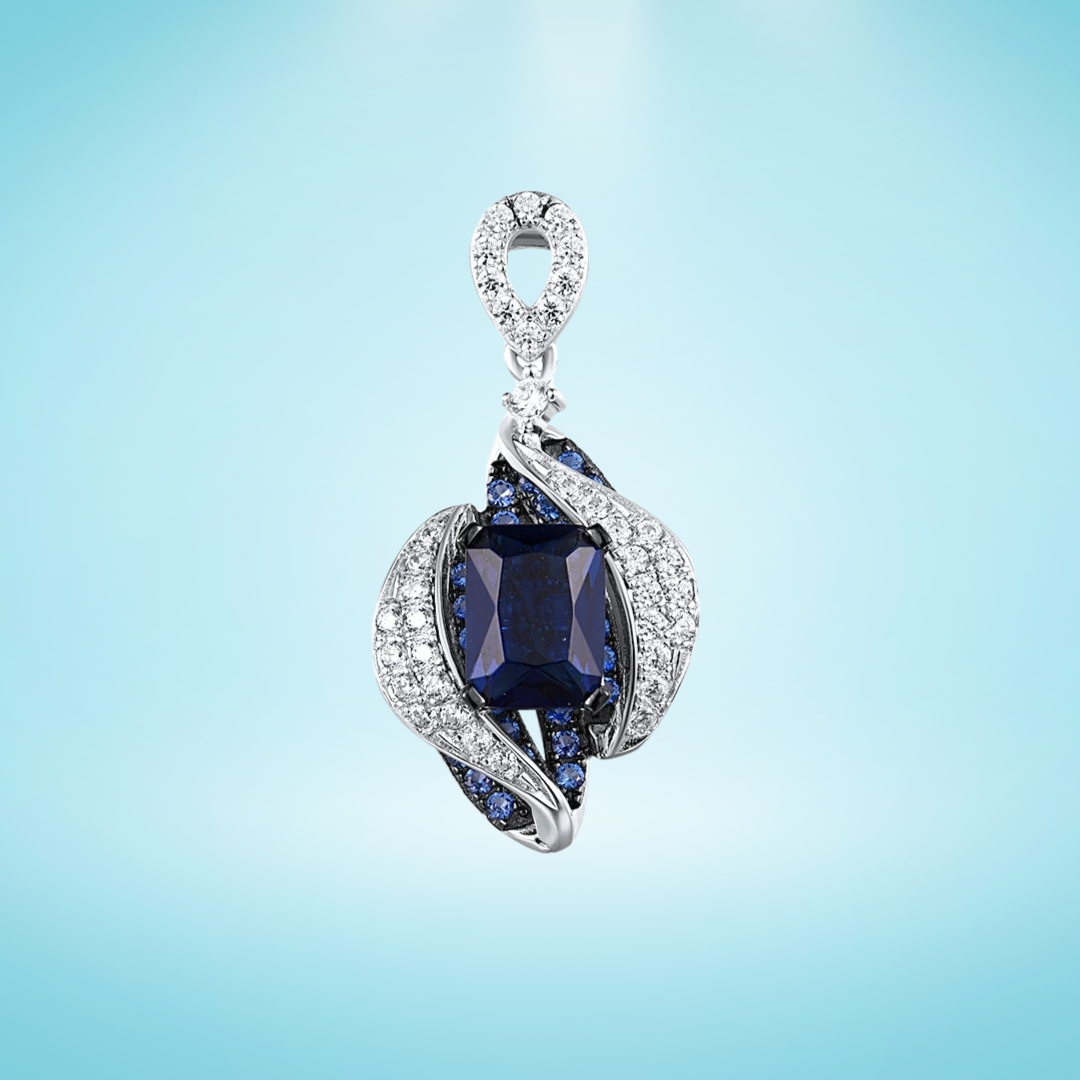 Sterling silver pendant with a rectangular dark blue gemstone surrounded by curving pavé-set bands and clustered blue stones