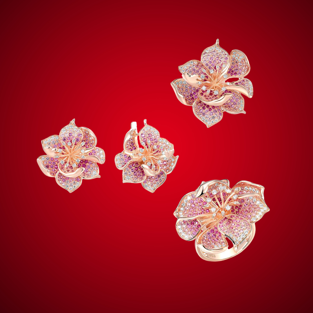 Fragola jewelry set featuring pink and violet pavé stones in rose gold flower designs including ring, earrings, and pendant.

