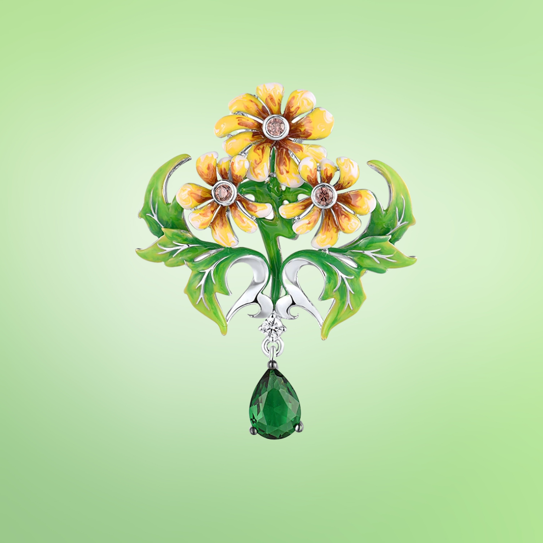 Brooch with three yellow enamel flowers, green enamel leaves, and a dangling green teardrop gemstone

