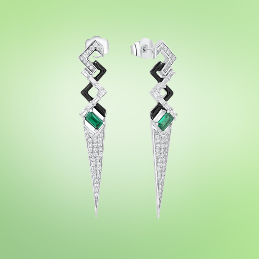 Long silver drop earrings with geometric shapes, black enamel accents, and green baguette-cut stones

