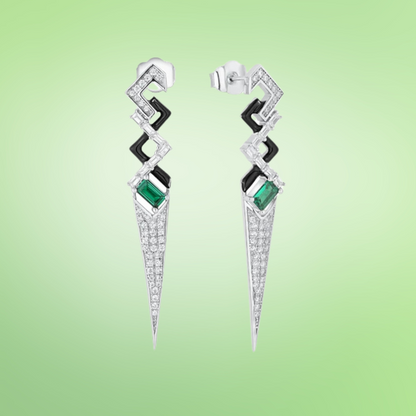 Long silver drop earrings with geometric shapes, black enamel accents, and green baguette-cut stones

