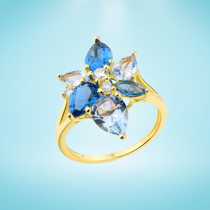 Gold-plated ring with a cluster of blue and clear gemstones in marquise and pear cuts arranged like flower petals

