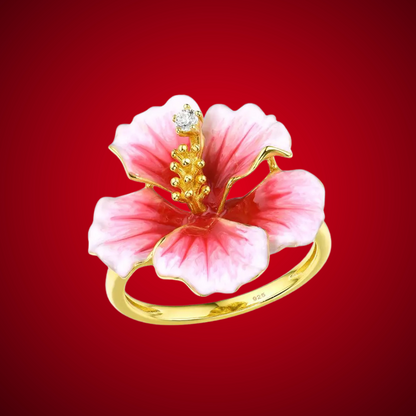 Prato ring shaped like a blooming hibiscus flower in pink enamel with golden stamen and a single sparkling white stone.

