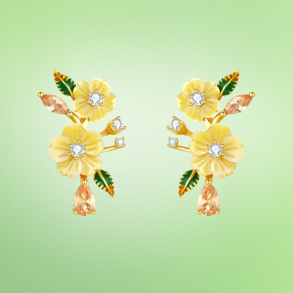 Yellow floral earrings with gemstone drops and green enamel leaves on gold setting

