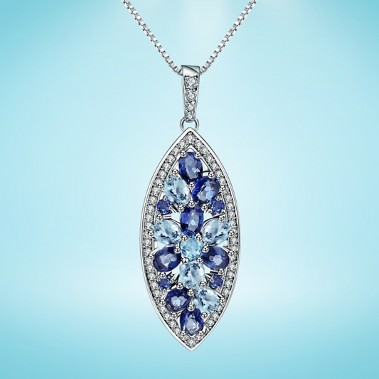 Marquise-shaped silver pendant with a floral arrangement of light and dark blue gemstones

