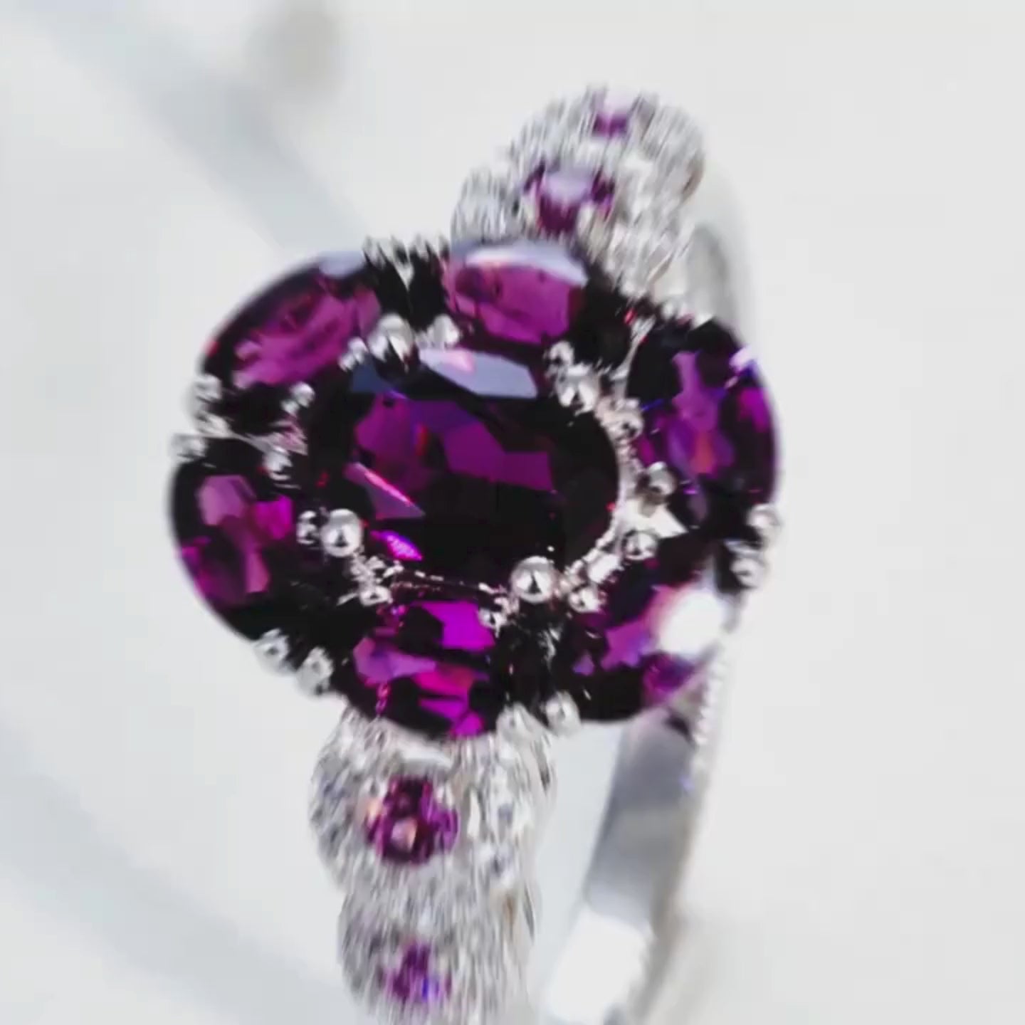 Silver ring featuring a bold cluster of deep red oval gemstones, framed by smaller accents, from the Rossa Collection.

