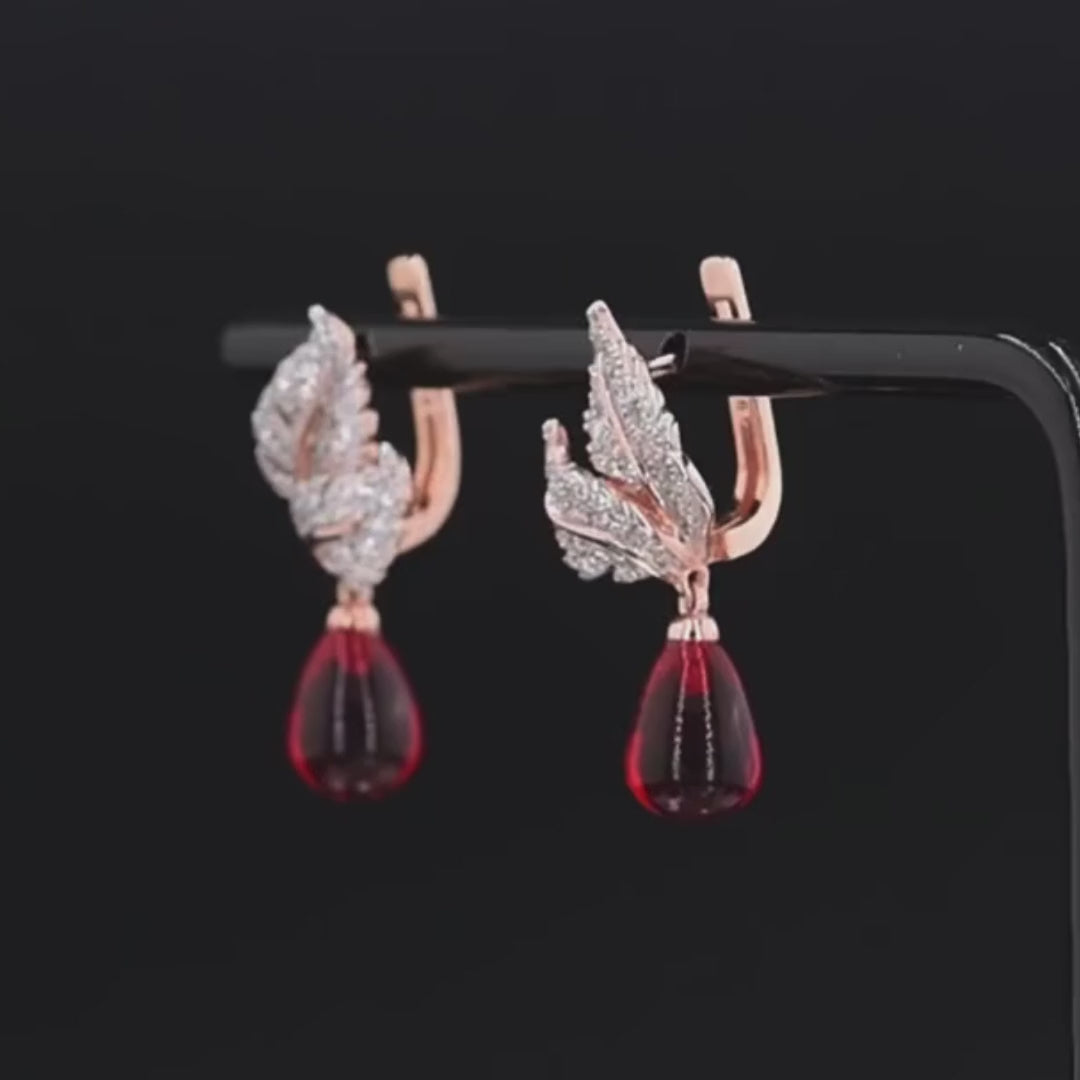 Lapino earrings with crystal-paved silver-tone leaves and rich red teardrop gemstone drops.

