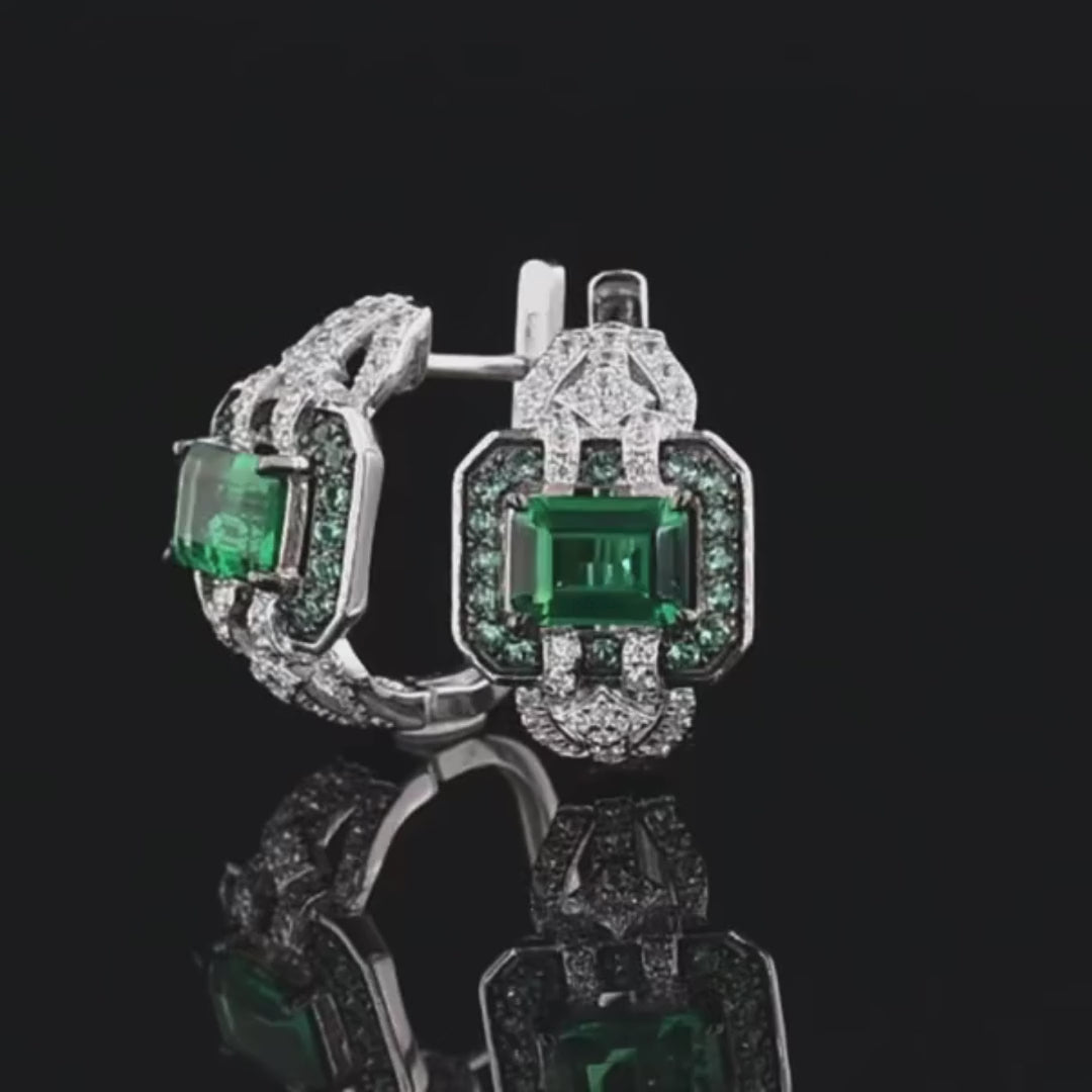 Octagonal silver earrings with emerald-cut green center stones, haloed by smaller green and clear stones

