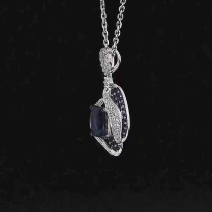 Sterling silver pendant with a rectangular dark blue gemstone surrounded by curving pavé-set bands and clustered blue stones