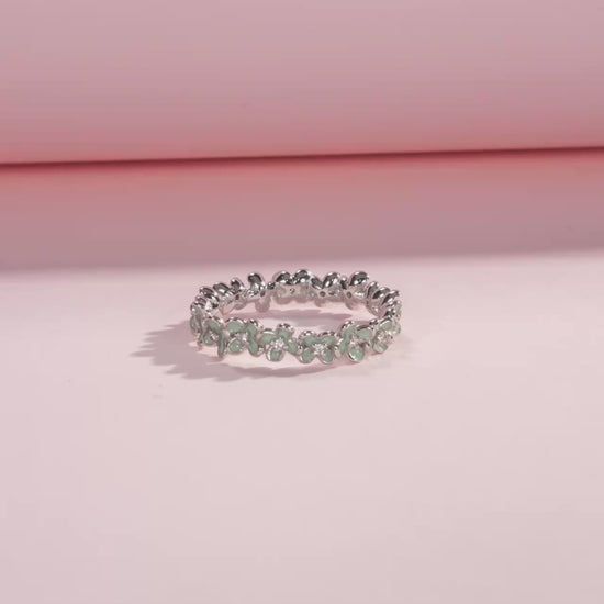 Sterling silver floral band ring with light green enamel petals and tiny diamond accents.

